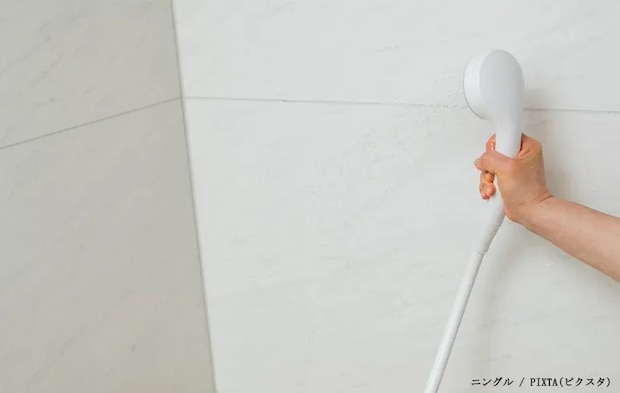 浴室の壁にシャワーをかける写真