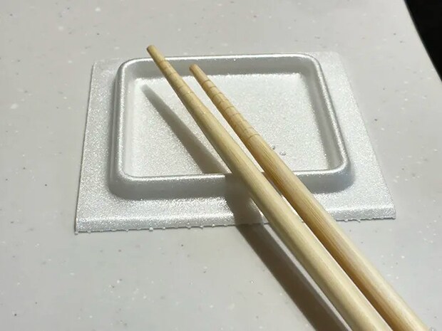 菜箸を乗せた納豆パックの蓋（撮影：grapeライフハック編集部）