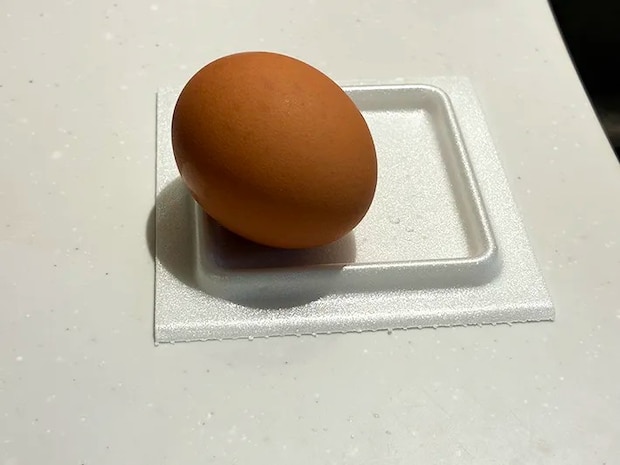 生卵を乗せた納豆パックの蓋（撮影：grapeライフハック編集部）