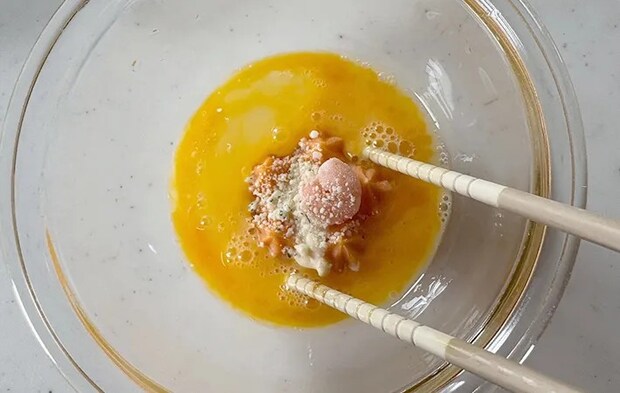 冷凍グラタンを卵にくぐらせている画像（撮影：エニママ）