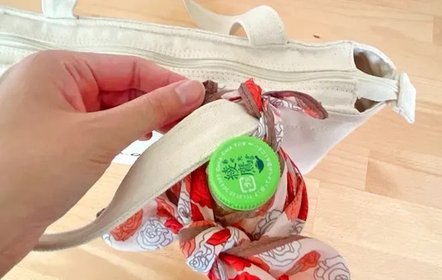 ペットボトルホルダーをバッグに取りつける写真（撮影：grapeライフハック編集部）