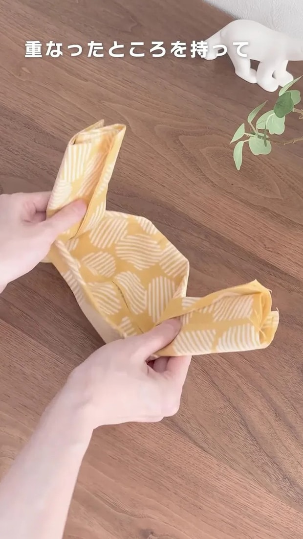 折った手ぬぐいの両側を持つ場面