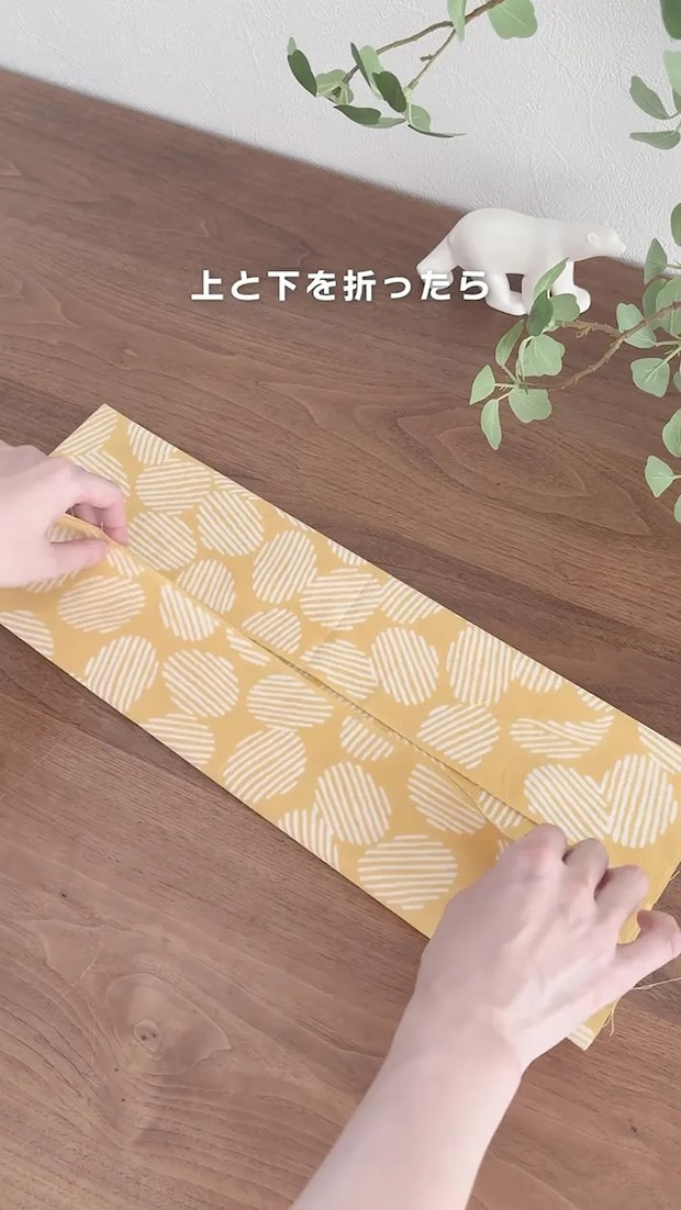 手ぬぐいの上側と下側を中央に向かって折り込む場面