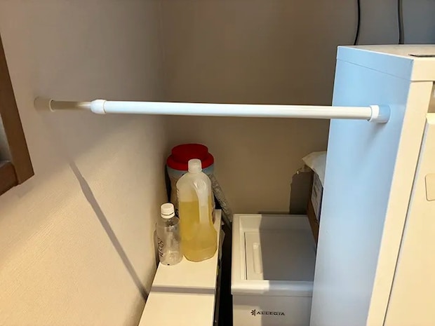 キッチンの壁と棚の間に渡したつっぱり棒（撮影：grapeライフハック編集部）