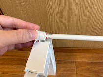 くぼみがある2個の白いパーツ　つっぱり棒と組み合わせると…「これで十分」「家族も喜んだ」
