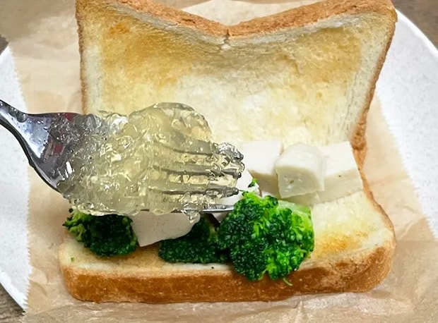 コンソメゼリーをサンドイッチにかける写真（撮影：grapeフード編集部）