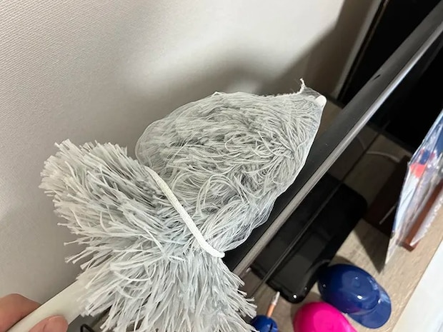 水切りネットをかぶせたハンディモップでテレビを掃除する場面（撮影：grapeライフハック編集部）
