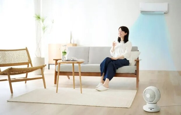 ソファに座る女性とエアコンの写真