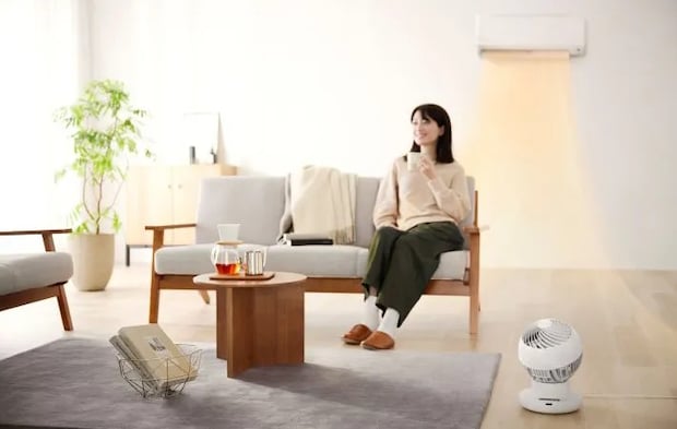 ソファに座る女性とエアコンの写真