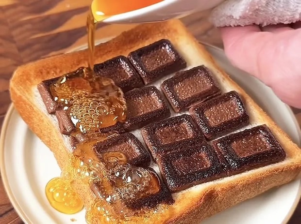 焼き上がったパンに加熱した砂糖と水をかけている画像
