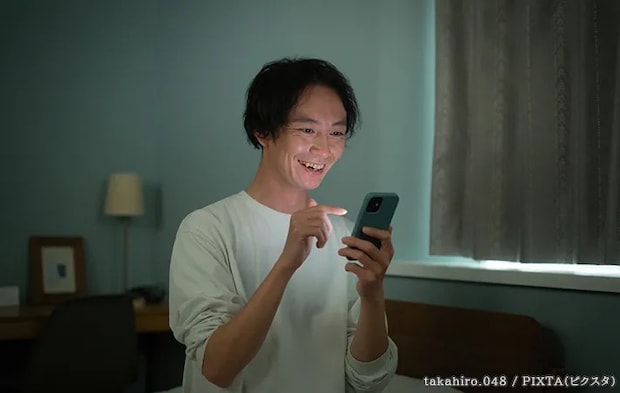 スマホを見る人の写真