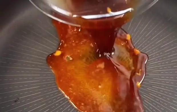 照り焼きソースをフライパンに投入している画像