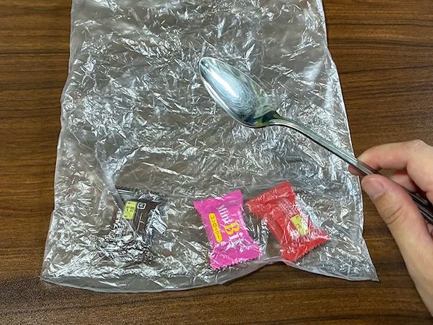 机に置かれたポリ袋と、指で持ったスプーン（撮影：grapeライフハック編集部）