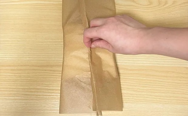クッキングシートの端を重ね合わせて巻く写真（撮影：grapeフード編集部）