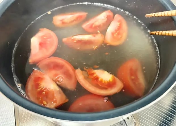 煮立ったスープにトマトを加えた画像（撮影：エニママ）