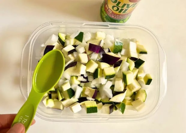 カットした野菜にオリーブオイルを加える（撮影：エニママ）