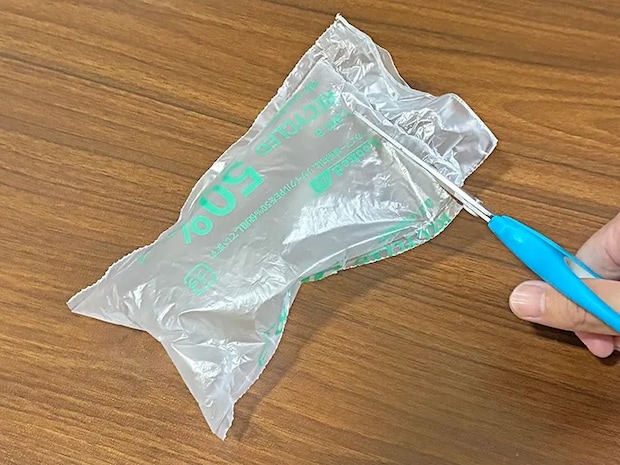エア緩衝材の端をハサミでカットする場面（撮影：grapeライフハック編集部）