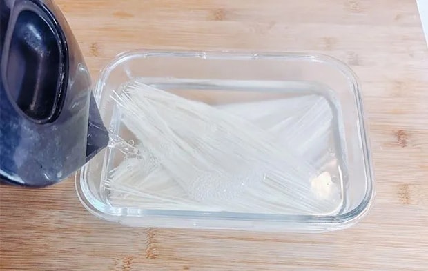そうめんを入れた耐熱容器にお湯を注ぐ画像（撮影：キジカク）