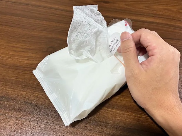 輪ゴムを巻いて、ウェットシート1枚を引き出そうとする場面（撮影：grapeライフハック編集部）