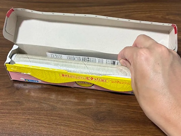 カット後のマグネットのパッケージを、ラップに差し込む場面（撮影：grapeライフハック編集部）