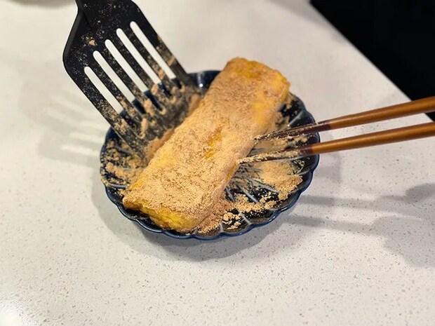 玉子焼きの表面にきな粉をまぶす写真（撮影：grapeフード編集部）