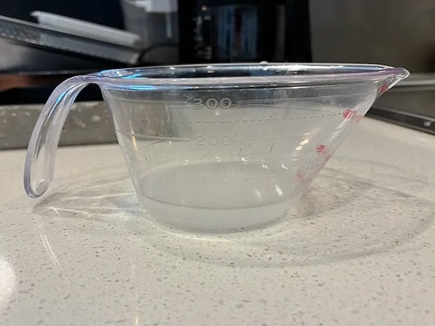 水切り後の水が入ったカップ（撮影：grapeフード編集部）