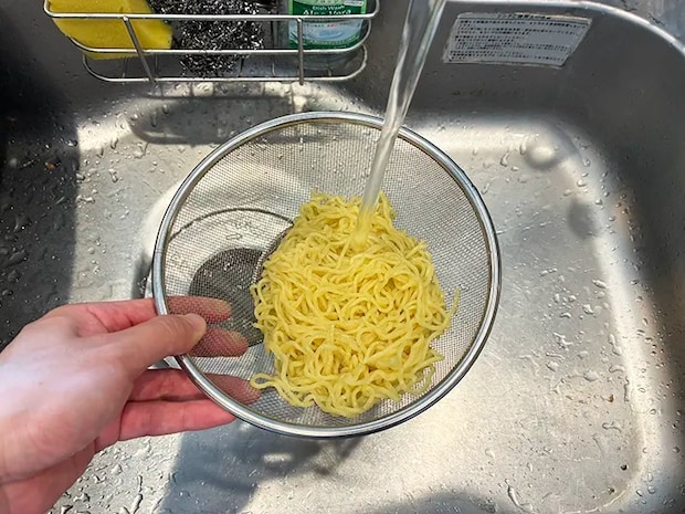 ゆでた中華麺を冷水で冷やす場面（撮影：grapeフード編集部）