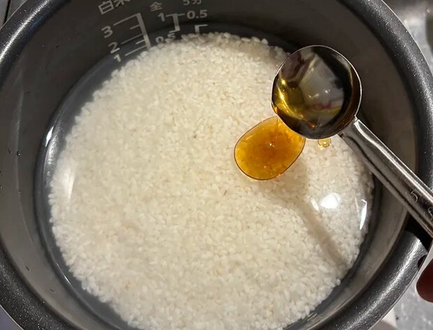 研いだお米にごま油を加える場面（撮影：grapeフード編集部）