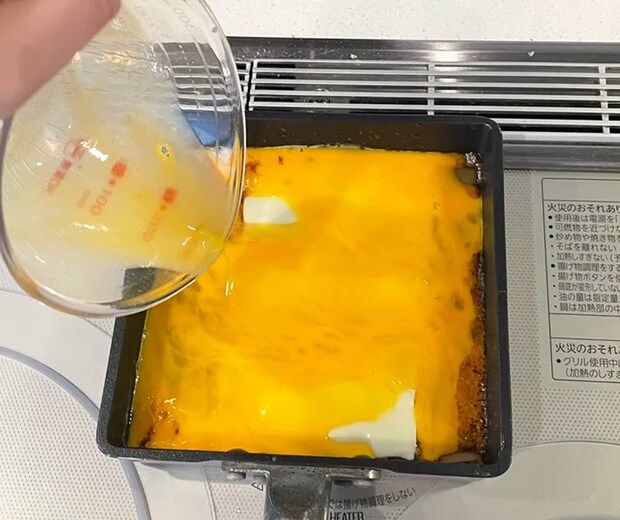 スライスチーズをのせて、溶き卵を注ぐ写真（撮影：grapeフード編集部）