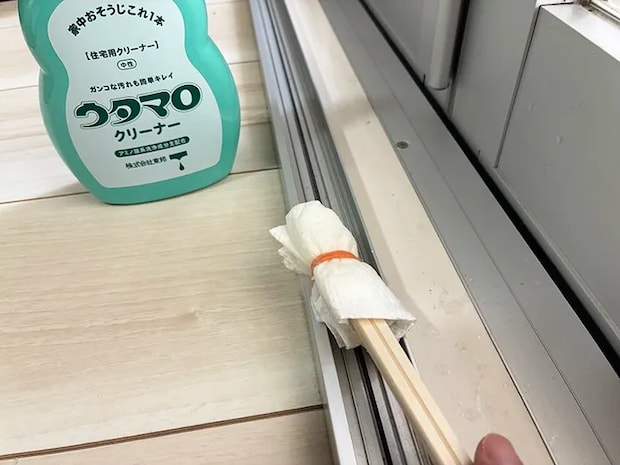 ウタマロクリーナーを含ませた簡易スティックでサッシを掃除する場面（撮影：grapeライフハック編集部）
