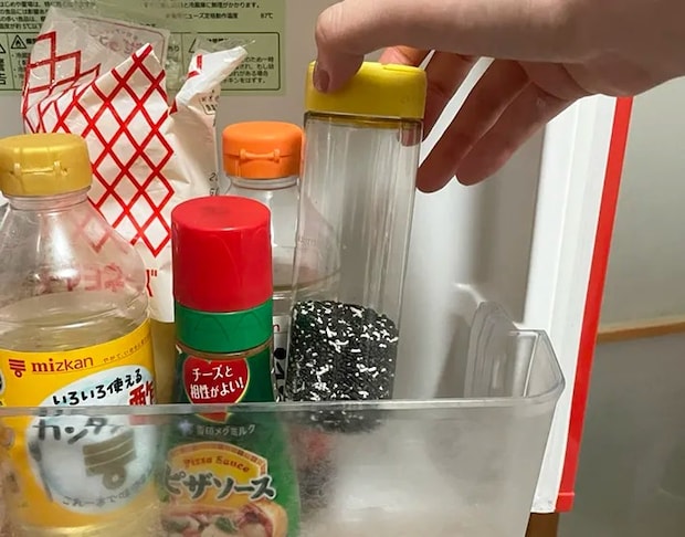 冷蔵庫に粉チーズの容器を入れる写真（撮影：grapeライフハック編集部）