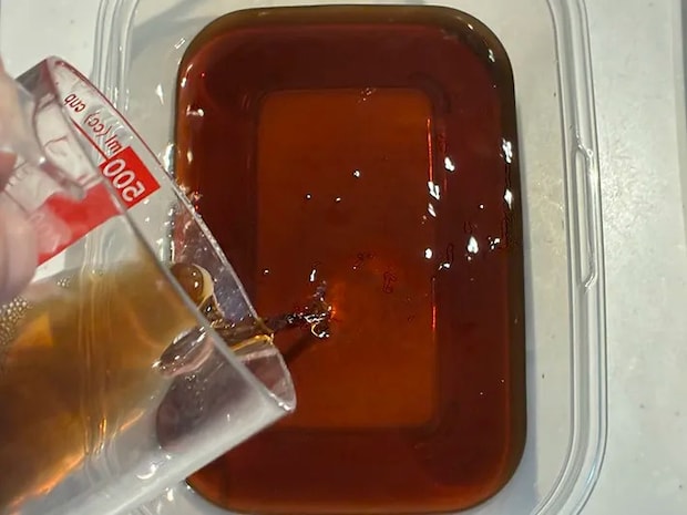 コーヒーをタッパーに注ぐ場面（撮影：grapeフード編集部）