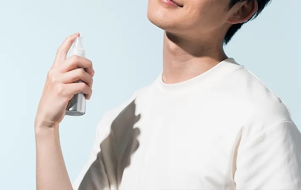 冷却スプレーを服の上からかける人の写真