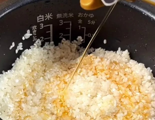 洗った米にごま油を回しかけている画像