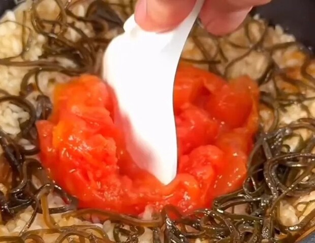トマトを崩しながら混ぜている画像