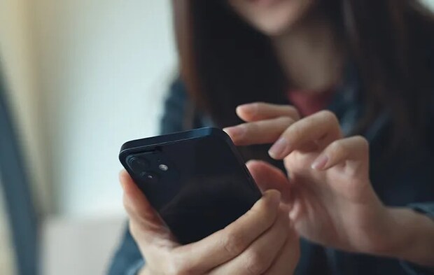 スマホを見る人の写真