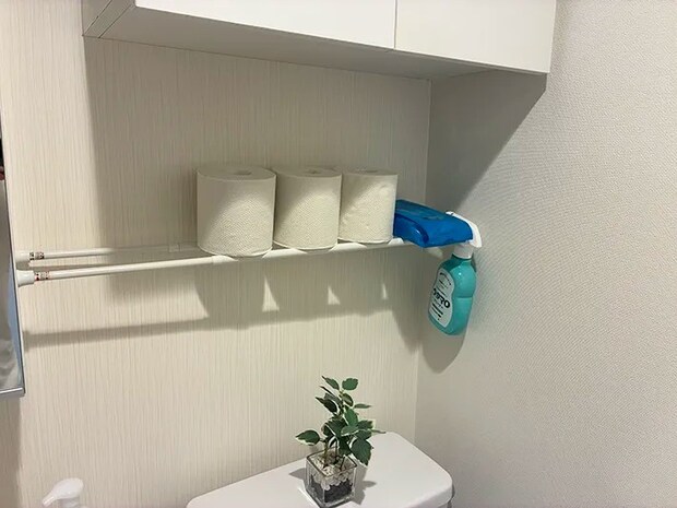 つっぱり棒の上に収納したトイレットペーパーや掃除用品（撮影：grapeライフハック編集部）