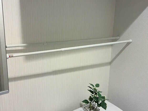 トイレタンクと戸棚の間に設置した2本のつっぱり棒（撮影：grapeライフハック編集部）