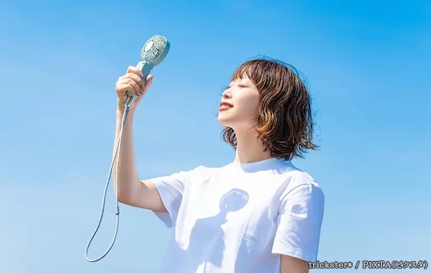 ハンディファンを使用する女性の写真
