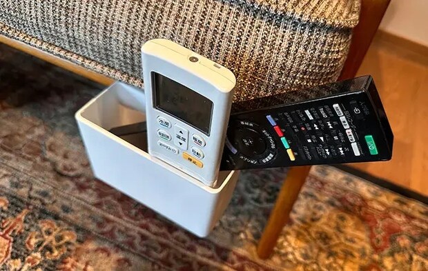 ソファの隙間にブックエンドを差し込み、マグネットケースをくっつけてリモコンを入れている写真（撮影：grapeライフハック編集部）