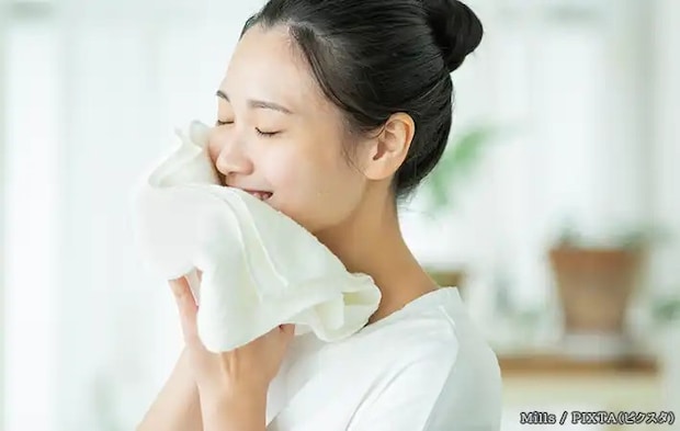 タオルで顔を拭く女性の写真