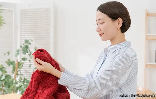 洋服を持つ女性の写真