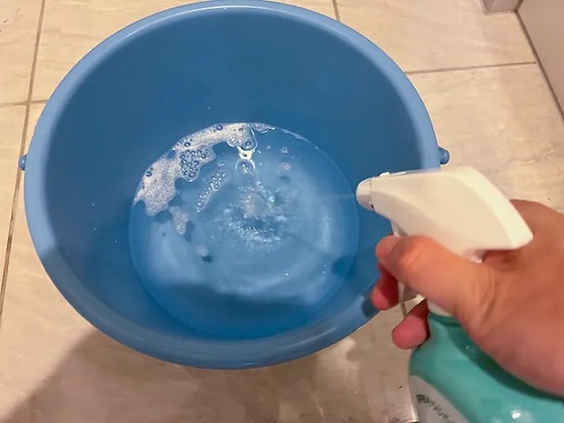 バケツの水にウタマロクリーナーをプッシュする場面（撮影：grapeライフハック編集部）