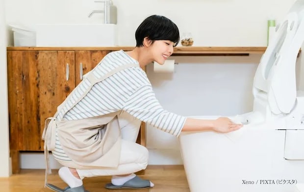 『トイレを掃除する若い女性』の写真