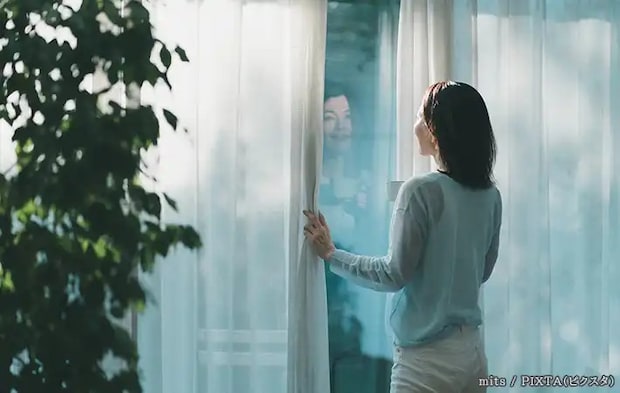 窓の外をみる人の写真