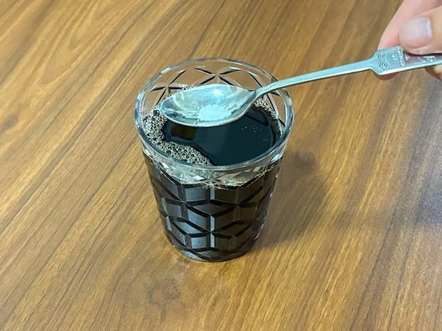 スプーンで少量の塩をコーヒーに加える場面（撮影：grapeフード編集部）