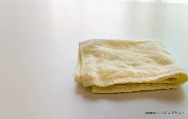 『テーブルの上にたたんで置かれた一枚のタオル』の写真