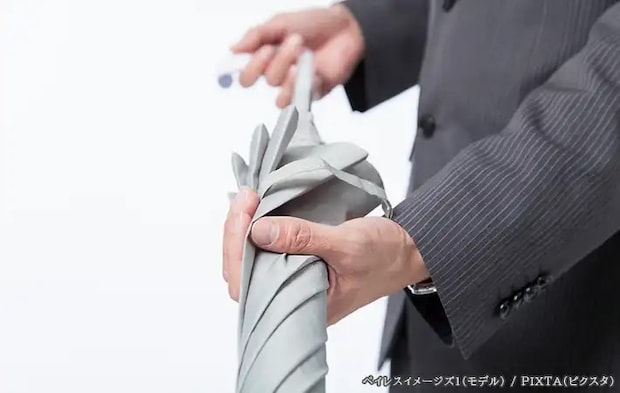 傘をたたむ人の写真