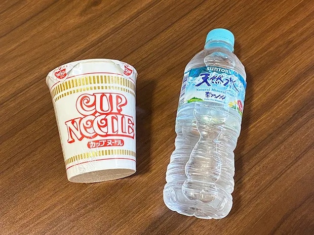 机に置かれたカップラーメンとミネラルウォーター（撮影：grapeライフハック編集部）