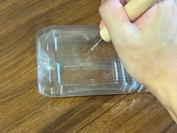 ペットボトルにキリで小さな穴を開ける場面（撮影：grapeライフハック編集部）